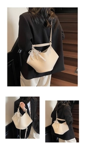 Close-up of beige lychee texture bucket bag with lace bow and pearl charm detail