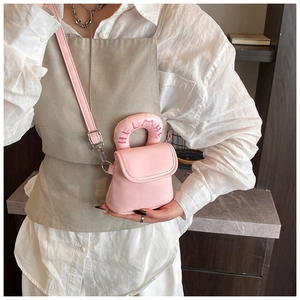Close-up of pink mini crossbody bag featuring adjustable strap and cat embroidery on handle
