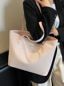 Pink woven texture tote bag with golden hardware and long shoulder straps for daily commute