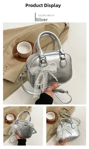 Détail du sac bowling argenté avec nœud en dentelle et breloques de perles pour femme
