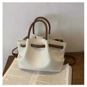 Close-up of pleated bucket bag with cream pebbled leather and contrast brown trim