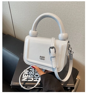 Détail du mini sac en cuir verni gris avec poignée ronde et fermoir boule en métal