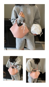 Detail view of pink litchi grain leather handbag with lace bow and pearl pendant