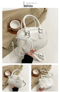 Détail du sac bowling en cuir blanc avec lettrage en relief et bordures en dentelle