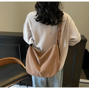Brown minimalist tote bag shown worn as a crossbody by a model for daily commuting