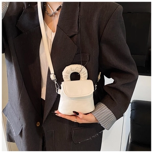Detail of white mini crossbody bag featuring embossed HELHE logo and feline relief handle