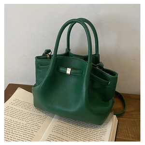 Detailed macro of green pebbled leather texture and elegant gold metal buckles on bag