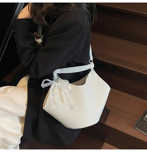 White litchi pattern hobo bag with lace and pearl bow charm on a stylish model