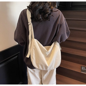 Detail of minimalist cream tote bag with adjustable wide strap worn by a model