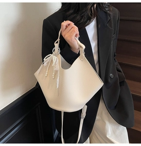 Chic beige bucket bag with lychee texture and pearl lace bow pendant detail