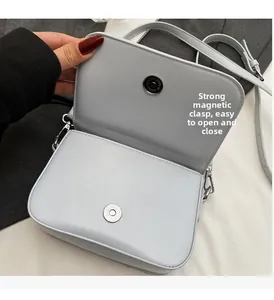 Détail du sac bandoulière bleu clair avec une fermeture à boucle magnétique argentée