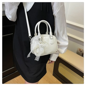 Détail d'un sac bowling blanc en cuir PU avec nœud en dentelle et perles chic