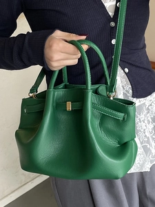 Minimalist grass green leather bucket bag with top handles and adjustable strap