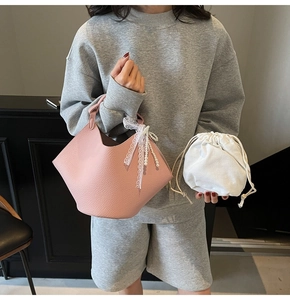 Pink litchi texture leather tote with white lace bow, pearl pendant and drawstring bag