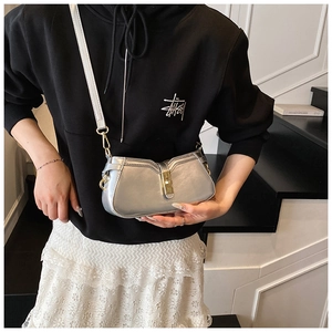 Détail du sac à bandoulière argenté métallisé avec fermoir doré porté par le mannequin