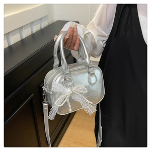 Détail du sac à main argenté métallisé avec nœud en dentelle perlée et gaufrage GOOD