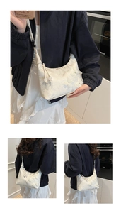 Close-up of white lace floral handbag with decorative tassel and slim shoulder strap