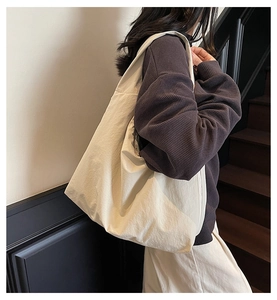 Vue détaillée du grand sac porté épaule blanc cassé montrant la texture et le design
