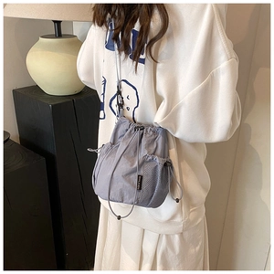 Detailansicht einer mauvefarbenen Beuteltasche mit Netztaschen und Kordelzugverschluss