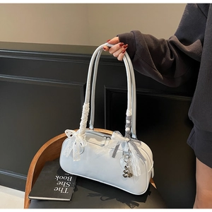 Detail of shoulder bag with lace bow, checkered ribbon and silver bear pendant