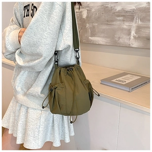 Olivgrüne Kordelzug-Beuteltasche mit Netztasche in einer legeren Lifestyle-Umgebung