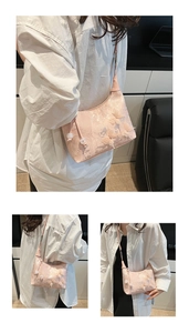 Detail of pink lace handbag featuring 3D butterfly embroidery and pearl charms