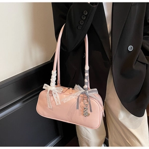 Pink patent leather bag with lace bow, ribbon, and silver heart charm details