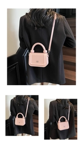 Détail du mini sac carré rose avec poignée cylindrique et finition en cuir verni brillant