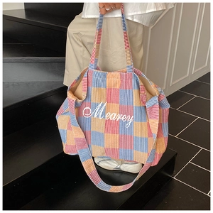 Detailed view of the checkered tote bag with Mearey embroidery on high-quality fabric