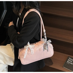 Close-up of pink Boston bag with lace bow, checkered ribbon and silver heart charm