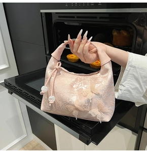 Detailed pink handbag featuring exquisite floral embroidery and 3D butterfly appliques