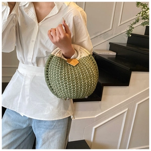 Detail view of woven straw handbag showing bi-color textures and leather patch