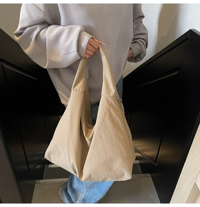 Detail of khaki large capacity tote bag with smooth nylon texture and side zipper