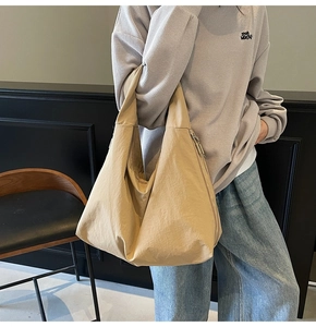 Detail of light khaki tote bag showing smooth matte texture and minimalist side zipper