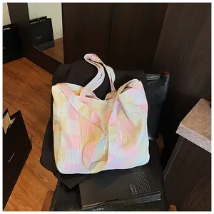 Detailed close-up of a colorful plaid canvas tote bag resting on an office chair