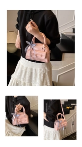 Détails d'un sac polochon rose rétro avec nœud décoratif et ruban à carreaux bleus