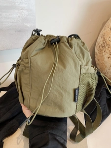 Minimalistische olivgrüne Kordelzug-Beuteltasche aus Nylon mit seitlichen Netztaschen