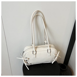 Dettaglio della borsa a spalla in pelle bianco panna con lacci laterali e occhielli argento