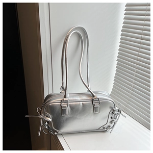 Dettaglio della borsa a spalla argento metallizzato con decorazioni stringate traforate