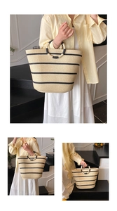 Detail of hand-woven straw tote with black stripes and circular handles for beach