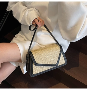 Detail of rainbow straw woven texture with black leather trim on minimalist crossbody bag