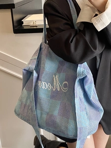 Blue plaid tote bag with Memory embroidery shown on a stylish model in a modern interior