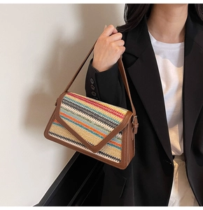 Detailed view of bohemian rainbow straw weave texture and brown leather trim on crossbody bag
