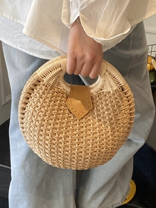 Handmade round straw woven handbag with leather buckle and top handle for summer vacation