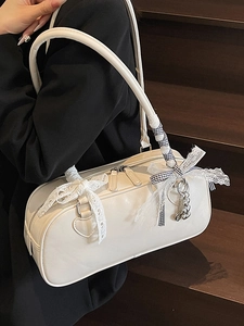 Elegant white leather Boston bag with lace bow and plaid strap on a model side view