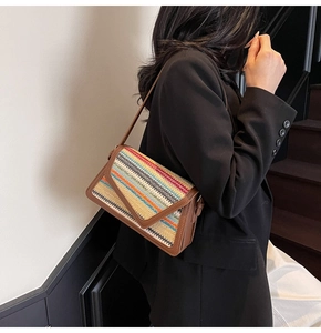 Close-up of retro striped woven texture and brown leather trim on the shoulder bag