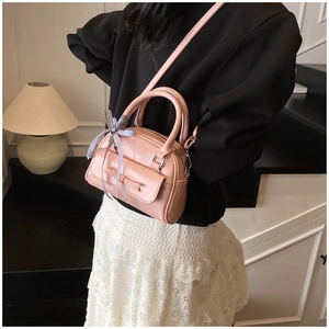 Sac rose en cuir verni avec détail de nœud élégant et ruban à carreaux chic