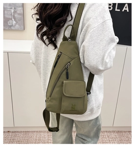 Detail of army green nylon crossbody bag showing multi-pocket structure and rabbit logo