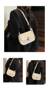 Detail view of cream vintage crossbody bag showing textured leather and metal buckle