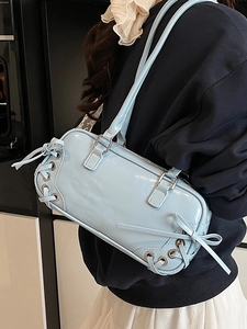 Borsa sottobraccio cilindrica azzurra con finitura lucida e dettaglio di lacci laterali